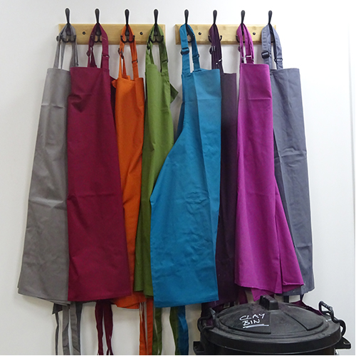 Coloured aprons hanging in the studio.