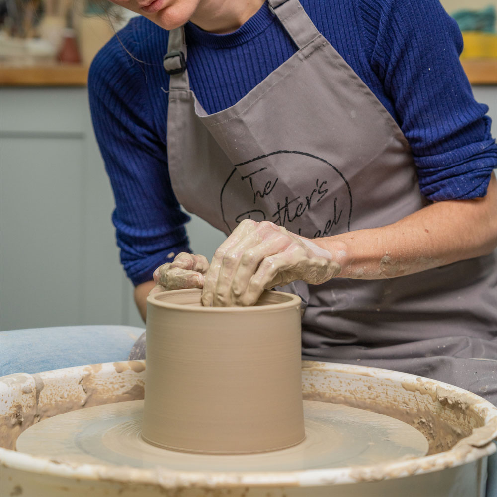 Emily throwing a pot on the wheel.